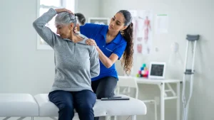 Practitioner massaging and stretching a client's neck and shoulder