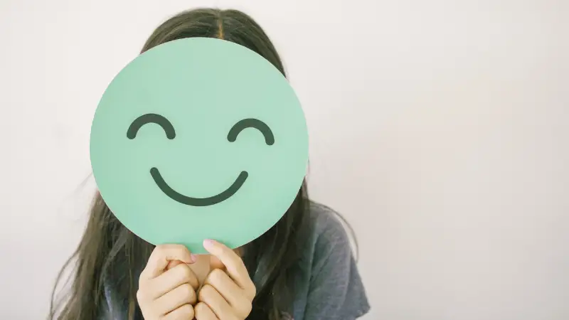 Person holding an of a smilie face