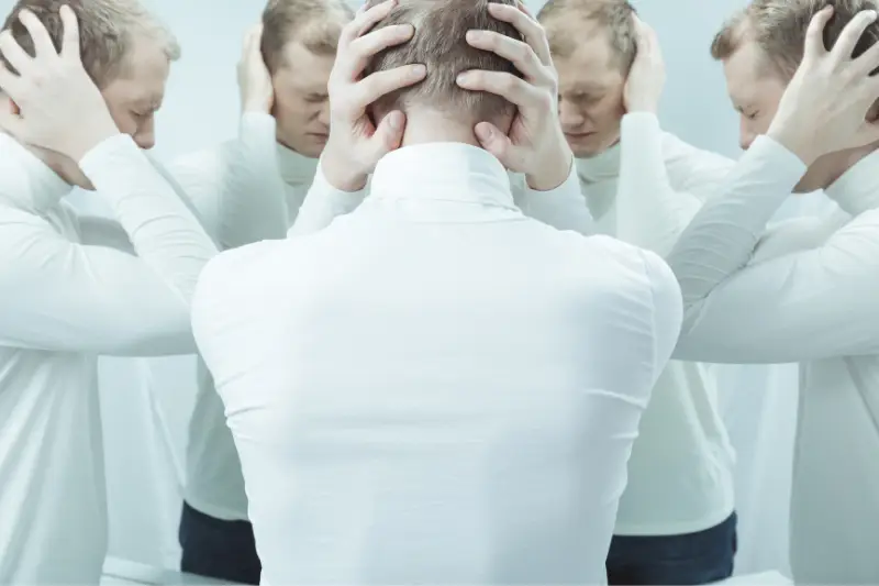 Anxiety1 A man having an anxiety attack, having his hands over his ears, with multiple copies of himself doing the same thing