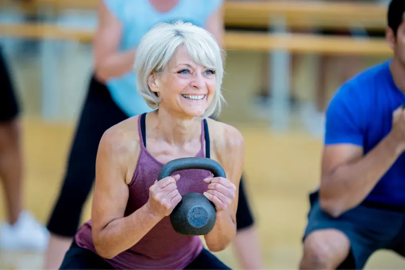 Make_your_exercise_fun1 A lady smiling, having fun while doing her exercises